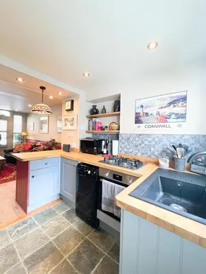 a kitchen with a sink and a stove top oven at Old Bookshop - Unique house in central St Ives with outdoor space in St Ives