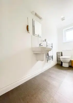 a white bathroom with a sink and a toilet at MINSTER DREAMS - A perfect seaside retreat for couples near Porthminster beach in St Ives