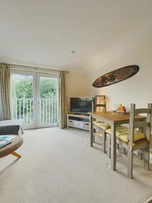 a living room with a table and a television at MINSTER DREAMS - A perfect seaside retreat for couples near Porthminster beach in St Ives