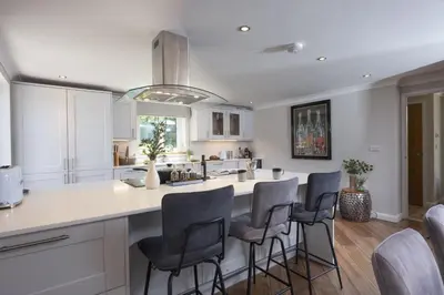 a kitchen with a large island with bar stools at Highfield Barton in Camborne