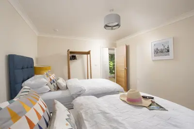 a bedroom with two beds with a hat on top at Highfield Barton in Camborne