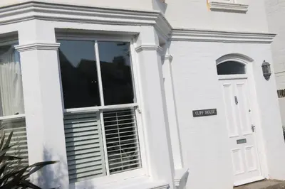 a white house with a window with a sign on it at Cliff House in Padstow