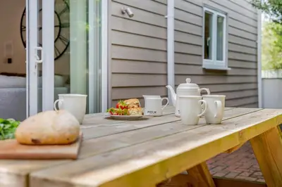 a wooden picnic table with a plate of food on it at 2 Bed in St. Issey oc-o27778 in Saint Issey