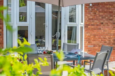 a table with chairs and an umbrella on a patio at 3 Bed in Newquay oc-c30862 in Newquay