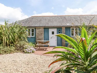 a cottage with a picnic table in front of it at Rose's Stable in Truro