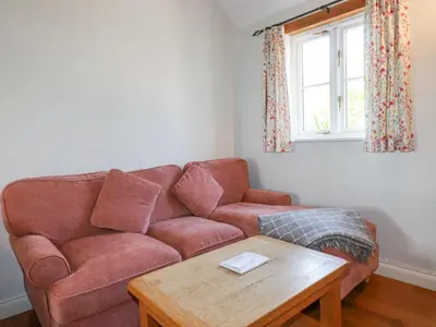 a living room with a couch and a table at Rose's Stable in Truro