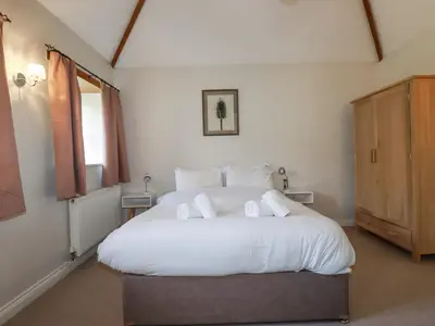 a bedroom with a large white bed with towels on it at Rose's Stable in Truro