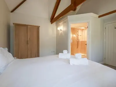 a bedroom with a large white bed with towels on it at Rose's Stable in Truro
