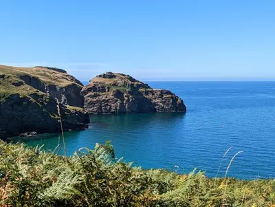 an island in the middle of a body of water at Menadue Cottage, Trenale Lane, Tintagel, Cornwall in Treknow