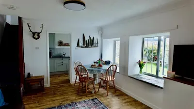 a kitchen and dining room with a table and chairs at Menadue Cottage, Trenale Lane, Tintagel, Cornwall in Treknow