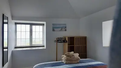 a bedroom with a bed with a towel on it at Menadue Cottage, Trenale Lane, Tintagel, Cornwall in Treknow