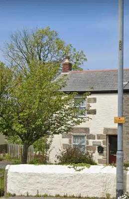 a house with a street sign in front of it at Cosy Cottage Close to the Beach with Hot Tub in Carnbrea Station