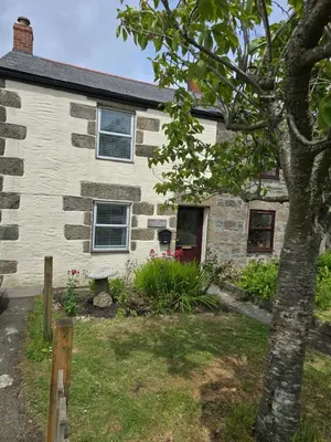 an old stone house with a tree in front of it at Cosy Cottage Close to the Beach with Hot Tub in Carnbrea Station