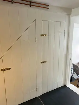 a room with white cabinets and ajar doors at Stunning seaside cottage Charlestown harbour in Charlestown