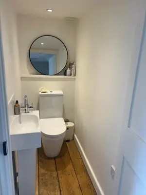 a bathroom with a white toilet and a mirror at Stunning seaside cottage Charlestown harbour in Charlestown