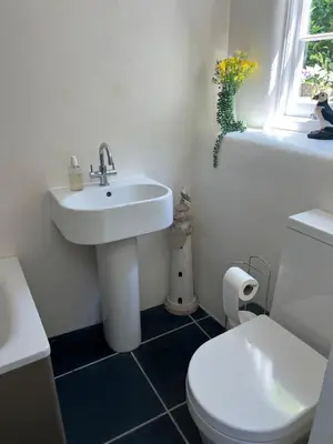 a bathroom with a sink and a toilet and a window at Stunning seaside cottage Charlestown harbour in Charlestown