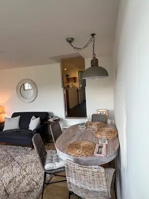 a living room with a table with chairs and a couch at Stunning seaside cottage Charlestown harbour in Charlestown