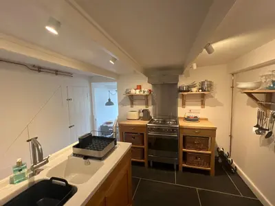 a small kitchen with a stove and a sink at Stunning seaside cottage Charlestown harbour in Charlestown