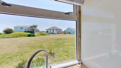 a view of a house from a kitchen window at F04 Penrhys, Rivere Towans in Hayle