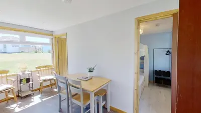 a kitchen and dining room with a table and chairs at F04 Penrhys, Rivere Towans in Hayle