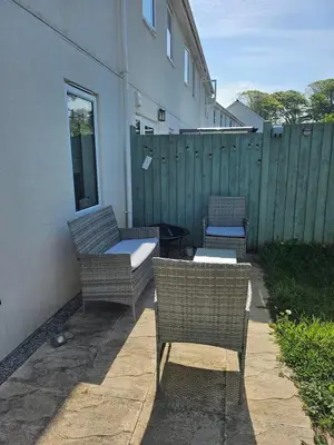 three wicker chairs and a table on a patio at House in Cornwall in Redruth