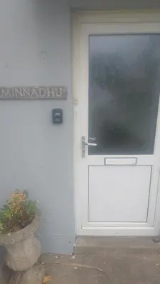 a white door with a sign on the side of a building at Minnadhu in Porthleven