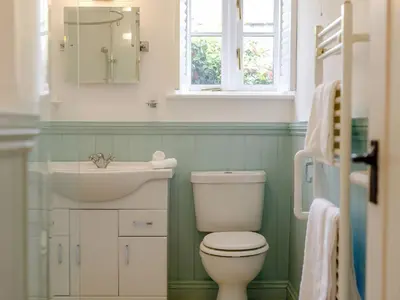 a bathroom with a white toilet and a sink at The Copper House in Truro
