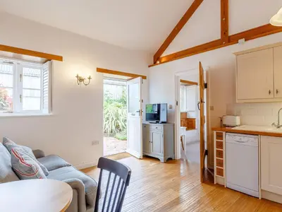 a kitchen and living room with a couch and a table at The Copper House in Truro