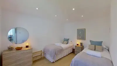a bedroom with two beds and a mirror at D26 Vu-An-Tecca, Riviere Towans in Hayle