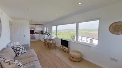 a living room with a couch and a large window at D26 Vu-An-Tecca, Riviere Towans in Hayle