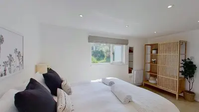 a bedroom with a large white bed and a window at D26 Vu-An-Tecca, Riviere Towans in Hayle