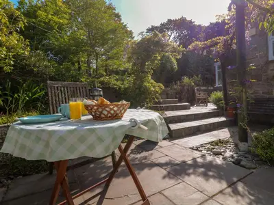 a picnic table with a basket of food on it at Little Acorns in Helston