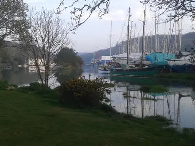 a group of boats are docked in a river at Little Acorns in Helston