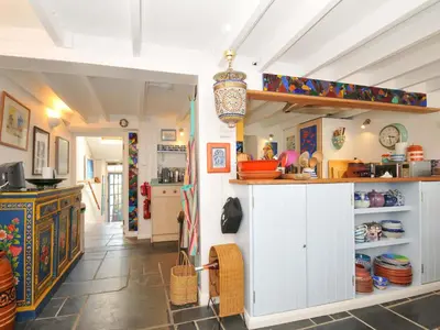 a kitchen with white cabinets and a counter at 5 Esplanade in Fowey