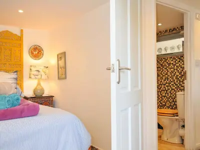 a bedroom with a bed and a bathroom with a toilet at 5 Esplanade in Fowey