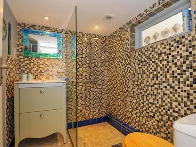 a bathroom with a shower with a glass door at 5 Esplanade in Fowey
