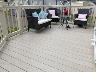 a deck with chairs and a table on it at 63 The Lea with decking Trevella Holiday Park in Crantock