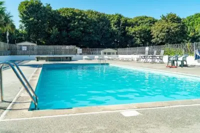a swimming pool with blue water in a yard at 63 The Lea with decking Trevella Holiday Park in Crantock