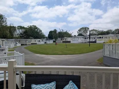 a view of a park from the deck of a house at 63 The Lea with decking Trevella Holiday Park in Crantock