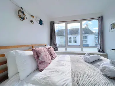 a bedroom with a bed and a large window at SURF PAD in St Ives, 1 Bed Apartment , 400M to Beach & Harbour in St Ives