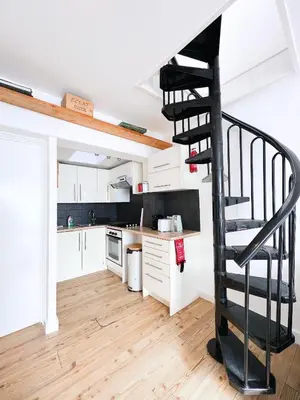 a kitchen with a spiral staircase in a loft at SURF PAD in St Ives, 1 Bed Apartment , 400M to Beach & Harbour in St Ives