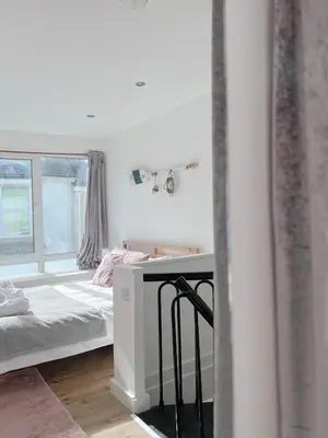 a bedroom with a bed and a desk and a window at SURF PAD in St Ives, 1 Bed Apartment , 400M to Beach & Harbour in St Ives