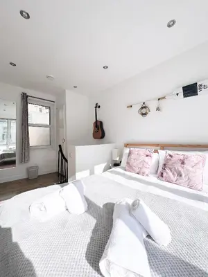 a bedroom with a large white bed with pink pillows at SURF PAD in St Ives, 1 Bed Apartment , 400M to Beach & Harbour in St Ives