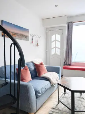 a living room with a blue couch and a table at SURF PAD in St Ives, 1 Bed Apartment , 400M to Beach & Harbour in St Ives