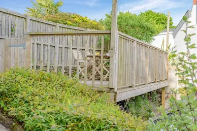 a wooden bridge over a yard with a table at 3 Bed in Egloshayle oc-m32201 in Egloshayle