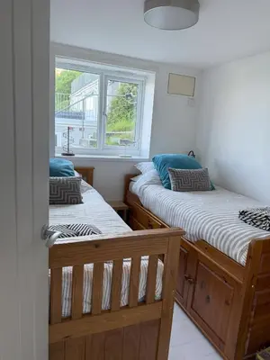 two twin beds in a room with a window at Shorething in Saint Martin