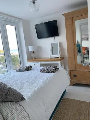a bedroom with a bed with a television on the wall at Shorething in Saint Martin