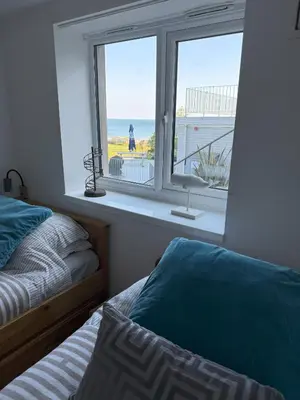 a bedroom with two beds and a window with a view of the ocean at Shorething in Saint Martin