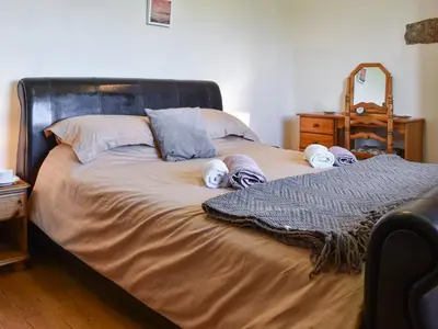 a bed with towels and pillows on top of it at Carriage House in Mawgan Porth