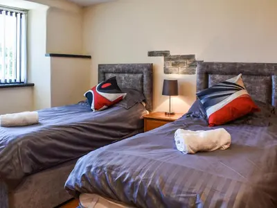 two beds sitting next to each other in a bedroom at Carriage House in Mawgan Porth